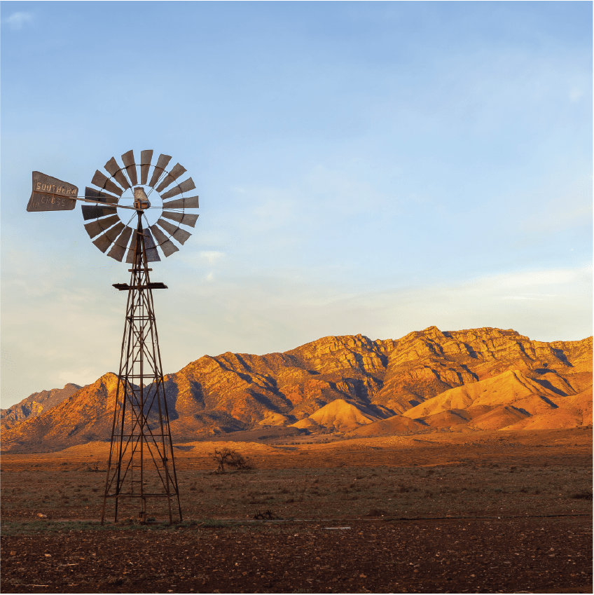 A windmill with the Flinders Ranges behind it in the Australian outback. Flinders Ranges National Park, South Australia, Australia.