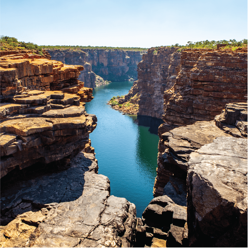 High angel view over King George River Gorge and plateau in the Kimberleys with lush bushes and sandstone formation in the foreground and background